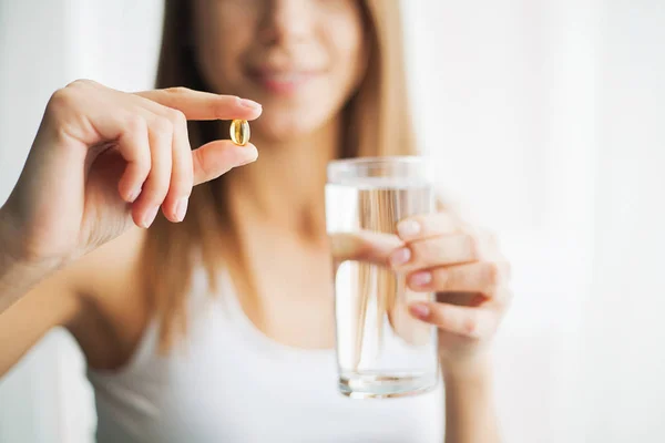 Vitamins and Supplements. Woman taking a tablet. Close up hand with a pill and the mouth. — Stock Photo, Image