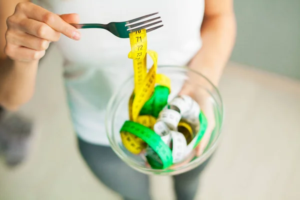 Dieta e Perda de Peso. Mulher segura tigela e garfo com fita métrica — Fotografia de Stock
