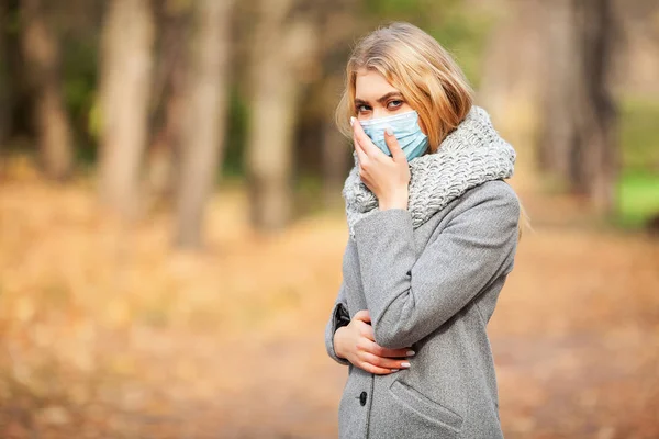 Resfriado y gripe. Mujer con mascarilla médica al aire libre — Foto de Stock