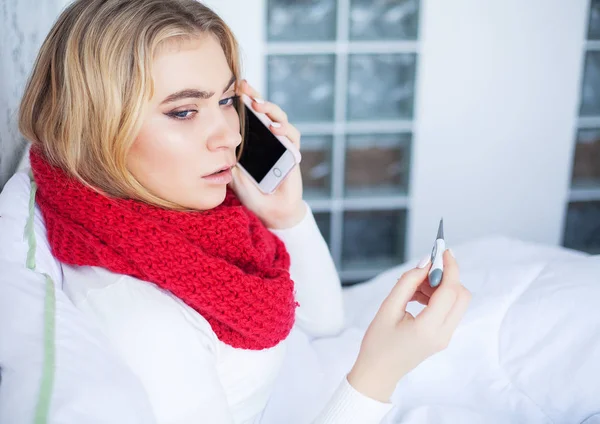 Hideg és az influenza. Beteg asszony feküdt egy ágyon egy hőmérővel — Stock Fotó