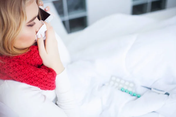 Frío y gripe. Mujer enferma en la cama en casa hablando por teléfono — Foto de Stock