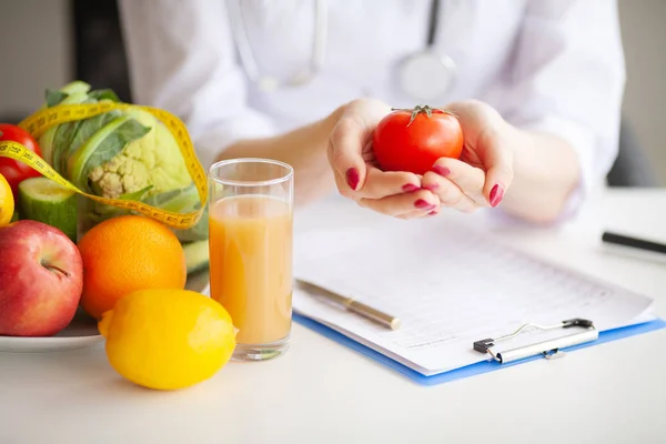 Photo conceptuelle d'une nutritionniste féminine avec des fruits sur le bureau — Photo