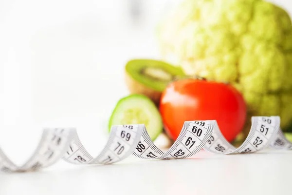 Ernährung. Fitness und gesunde Ernährung. ausgewogene Ernährung mit Gemüse. frisches grünes Gemüse, Maßband auf weißem Hintergrund. Nahaufnahme — Stockfoto