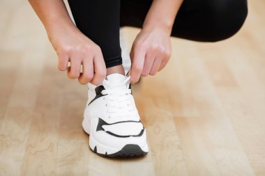Fiziksel aktivite. Spor salonunda spor ayakkabıları ayakkabı bağcığı bağlama kız Close-up