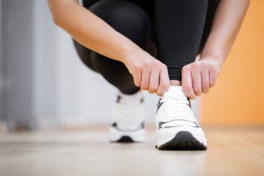 Fiziksel aktivite. Spor salonunda spor ayakkabıları ayakkabı bağcığı bağlama kız Close-up
