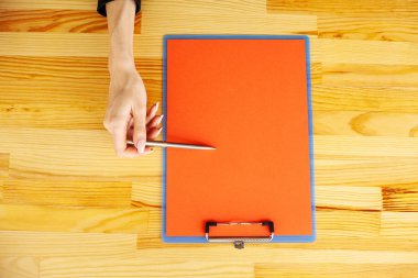 Office el a ağıl ile bir kırmızı renk kağıt ve kalem ahşap masa arka plan üzerinde tutarak. Boşaltmak. Metin için yer