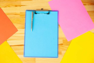 Bir klasörü bir mavi renk kağıt ahşap masa arka plan üzerinde tutan office el. Boşaltmak. Metin için yer