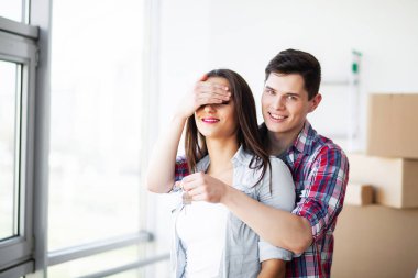 Yeni ev. Komik genç çift zevk ve yeni eve taşıdıktan kutluyor. Boş oda mutlu çifte yeni ev