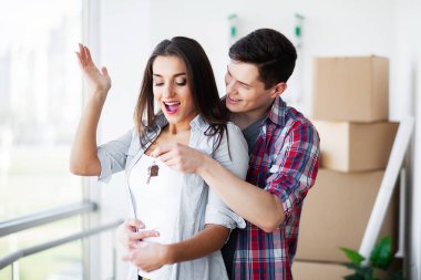 Yeni ev. Komik genç çift zevk ve yeni eve taşıdıktan kutluyor. Boş oda mutlu çifte yeni ev