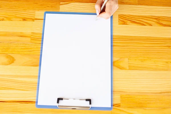 Úřad ruky držící složku s bílou barvu papíru na pozadí dřevěného stolu. Copyspace. Místo pro Text — Stock fotografie