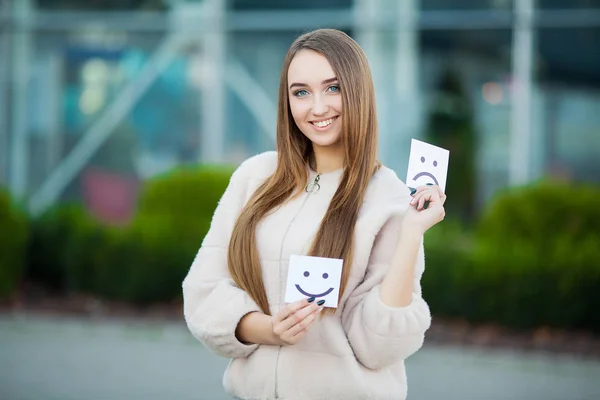 Schöne Frau mit Karten mit traurigem und lustigem Lächeln — Stockfoto