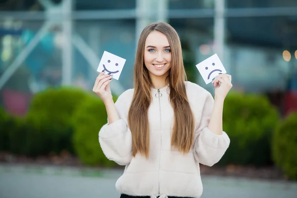 Mooie vrouw bedrijf kaarten met verdrietig en grappige glimlach — Stockfoto