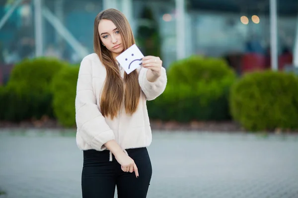 Beautiful woman holding card with sad smile — Stock Photo, Image