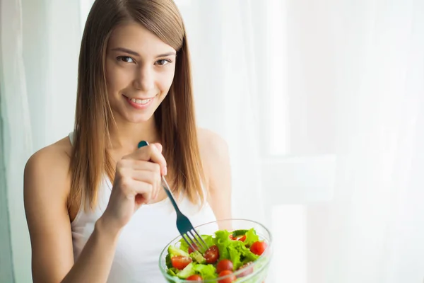 Diet and health. Young woman eating healthy salad after workout