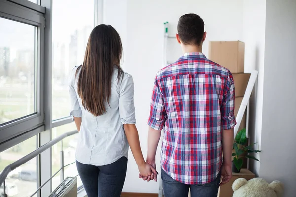 Nya hem. Roliga unga par njuta och fira flytta till nya hem. Lyckliga paret på tomt rum i nya hem — Stockfoto