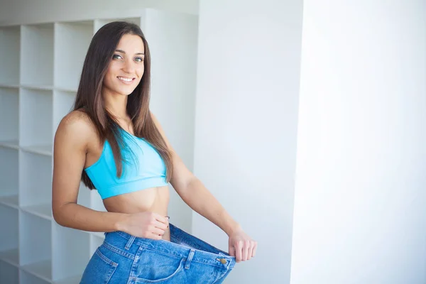 Uno stile di vita sano. Bella ragazza magra gioiosa che mostra il risultato della dieta — Foto Stock