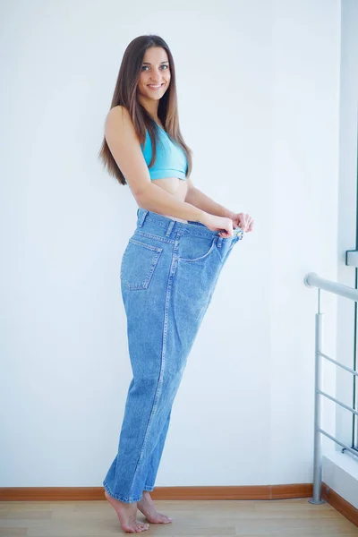 Estilo de vida saudável. Menina fina alegre bonita que mostra o resultado da dieta — Fotografia de Stock