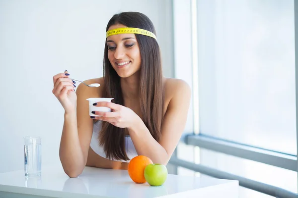 Nutrição saudável e conceito de dieta. Mulher segurando iogurte dentro de casa — Fotografia de Stock