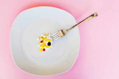 Hapları kapatın. Diyet takviyeleri. Çeşitli hap. Vitamini kapsülleri pembe bir arka plan üzerinde