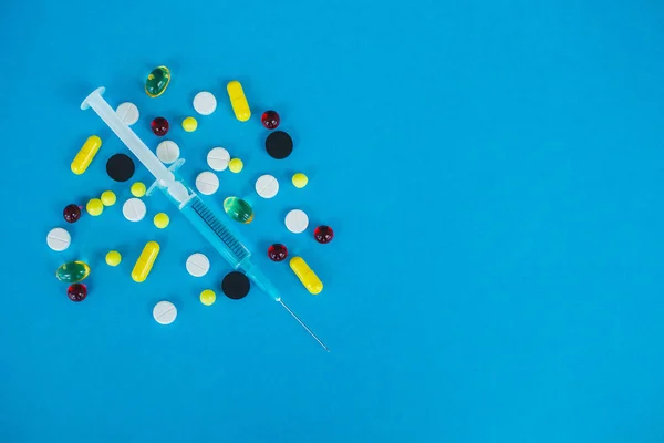 Píldoras médicas. Píldoras de color y cápsula sobre fondo azul. Tema de la farmacia, píldoras de la cápsula con antibióticos de la medicina en paquetes — Foto de Stock