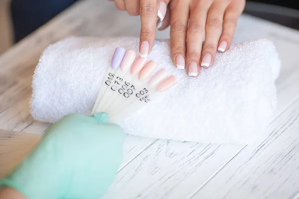 Manicure. Skillful master of manicure holding file in her hands while working in her beauty salon