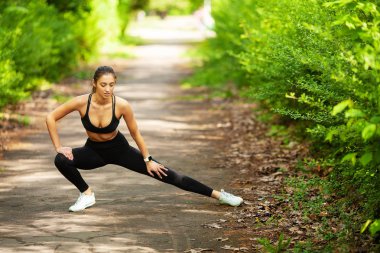 Kız spor yapıyor. Genç kadın bir parkta egzersiz
