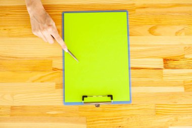 Office el a ağıl ile yeşil renk kağıt ve kalem ahşap masa arka plan üzerinde tutarak. Boşaltmak. Metin için yer