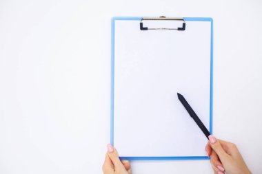 Bir klasör arka plan beyaz tablo hakkında bir beyaz renk kağıt tutan office el. Boşaltmak. Metin için yer