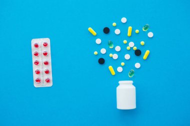 Tıbbi ilaçlar. Renkli hap ve kapsül mavi zemin üzerine. Eczane tema, kapsül hap ilaç antibiyotik paketleri ile