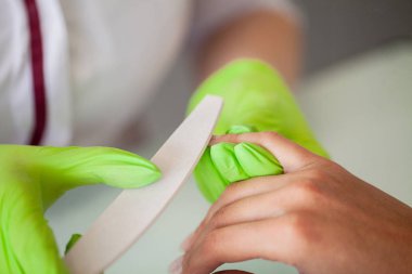 Manikür. Usta onun güzellik salonunda çalışırken dosya onun elinde tutan manikür ustası