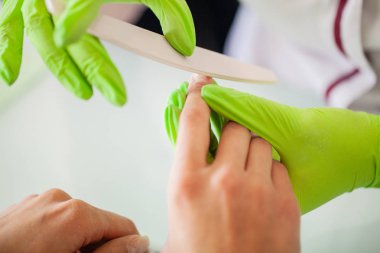 Manikür. Usta onun güzellik salonunda çalışırken dosya onun elinde tutan manikür ustası