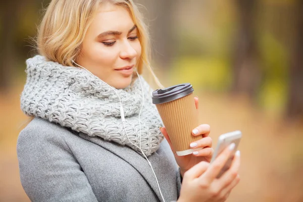 Café para llevar. Mujer joven con café en el parque de otoño — Foto de Stock