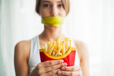 Yemek yeme. Patates kızartması ile komik genç ve güzel kadın