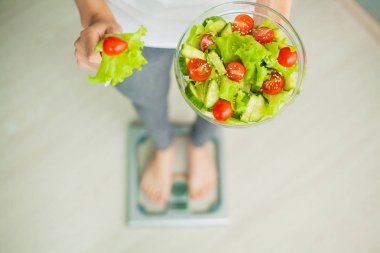 Sağlık. İnce kız tutmak ellerini taze salata içinde. Sağlıklı beslenme. Diyet. Yüksek çözünürlük