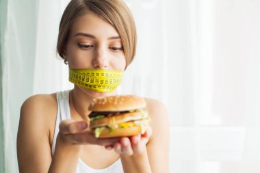 Diyet. Ona abur cubur yemek önlenmesi genç kadınla koli bandı içinde onun ağız. Sağlıklı beslenme kavramı