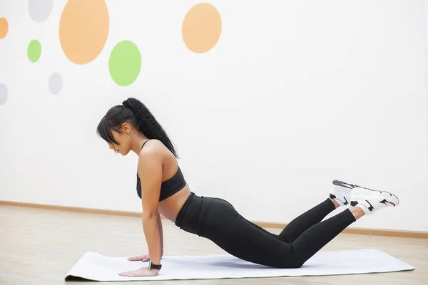 Jeune belle femme fait des pompes dans la salle de gym. Fitness girl séance d'entraînement dans la salle de gym — Photo