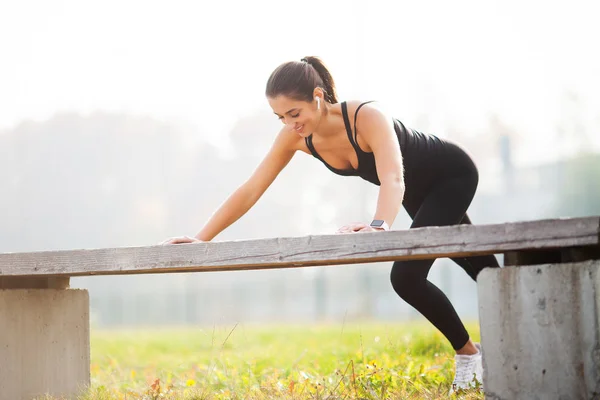 Fitness. Mujer atlética de pie en posición de tablón al aire libre al atardecer. Concepto de deporte, recreación y motivación — Foto de Stock