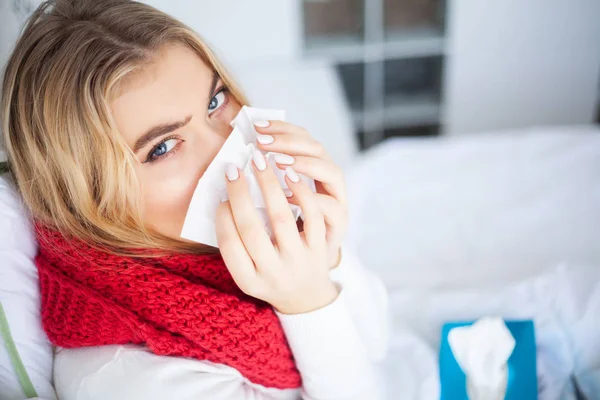 Kranke Frau. Frau mit Grippevirus liegt im Bett und misst ihre Temperatur mit Thermometer — Stockfoto