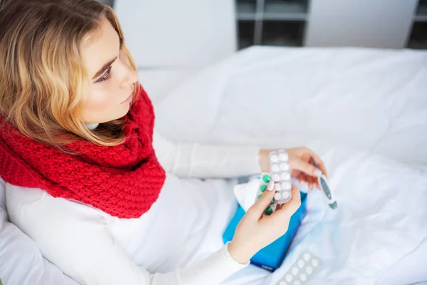 Zieke vrouw. Vrouw met griep in bed liggen, ze is haar temperatuur meten met een thermometer — Stockfoto