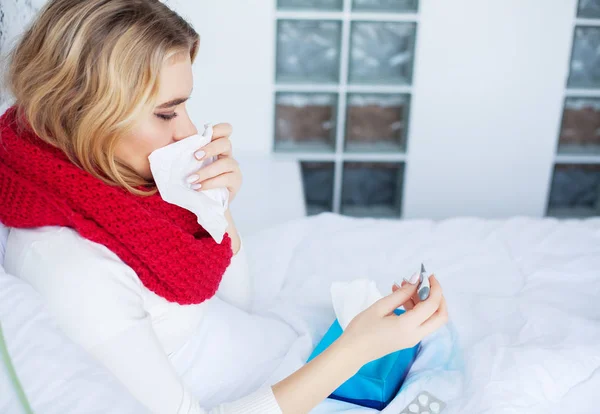 Nemocná žena. Žena s virem chřipky, ležící v posteli, ona je měření její teploty s teploměrem — Stock fotografie