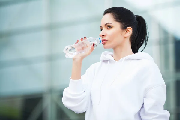 Фитнес. Концепция спорта и здорового образа жизни - женщина пьет воду после тренировки в парке — стоковое фото