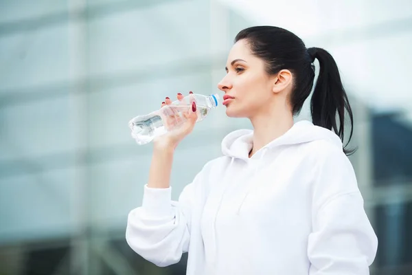 Фитнес. Концепция спорта и здорового образа жизни - женщина пьет воду после тренировки в парке — стоковое фото