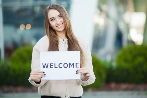 Women business with the poster with welcome message