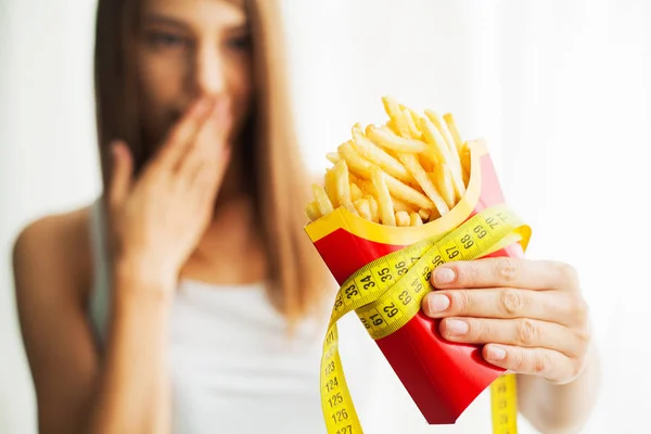 Dieta. Woman Measuring Body Weight On Weighing Scale Holding Unhealthy Junk Food (en inglés). La pérdida de peso. Obesidad. Vista superior — Foto de Stock