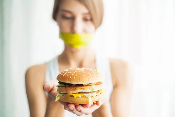 Régime alimentaire. Jeune femme avec du ruban adhésif sur la bouche, l'empêchant de manger de la malbouffe. Concept de saine alimentation — Photo