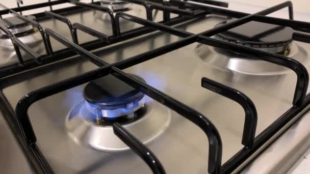 Stove burner igniting into a blue cooking flame — Stock Video
