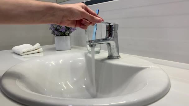 Мужчина моет руки под краном в ванной — стоковое видео