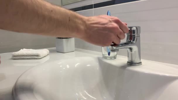 Man wassen zijn handen onder de kraan in de badkamer — Stockvideo