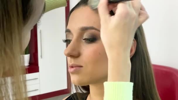 Concepto de belleza. Maquillaje artista haciendo maquillaje de cara a la mujer joven — Vídeos de Stock