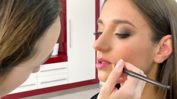 Concept beauté. maquilleur faire visage maquillage pour jeune femme — Video